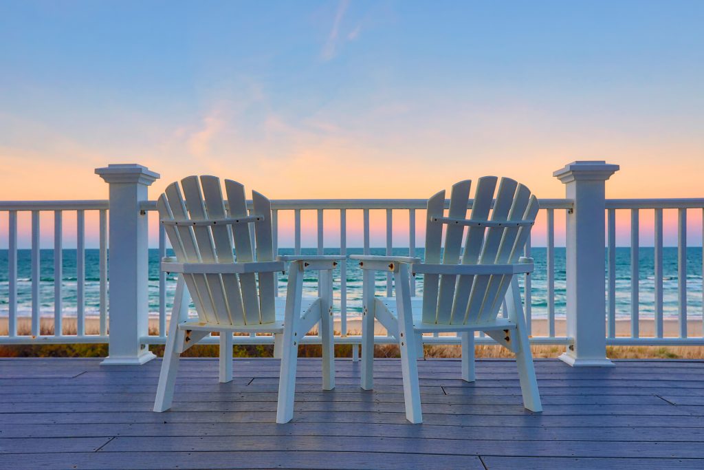 View of two chairs on the deck at sunset | Carolina Retreats